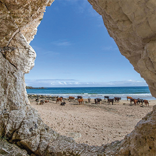 A beach looked at through a rock formation.